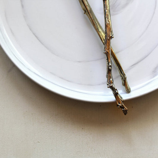 Detail of handles on handmade Sterling and Brass Cake Servers with Branch Handles and Hammered Texture. 